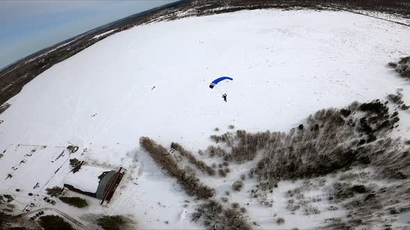 FPV Shooting of a Parachutist Flying Over a Winter Field