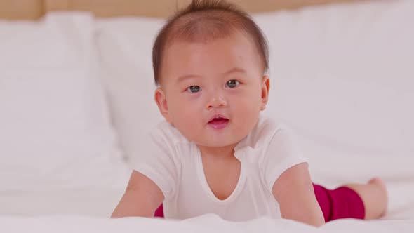 Happy Newborn baby laying on stomach developing neck control .tummy time for strengthen baby neck an alt