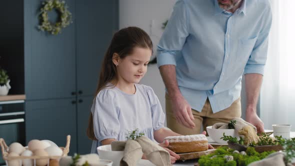 Little girl helping parents in preparing easter table for dinner. Shot with RED helium camera in 8K. alt