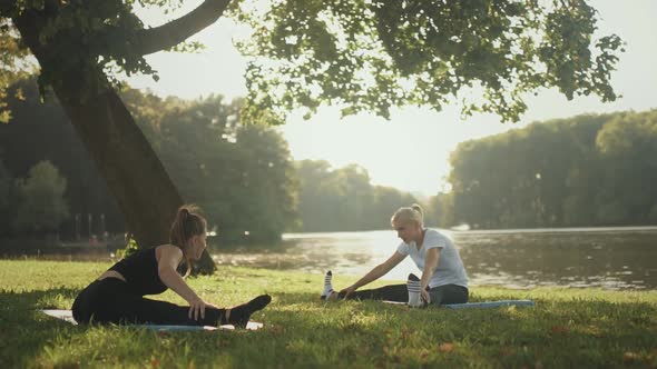 Two Women Practicing Yoga in Park