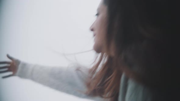 Young woman in her balcony smiling to the camera alt