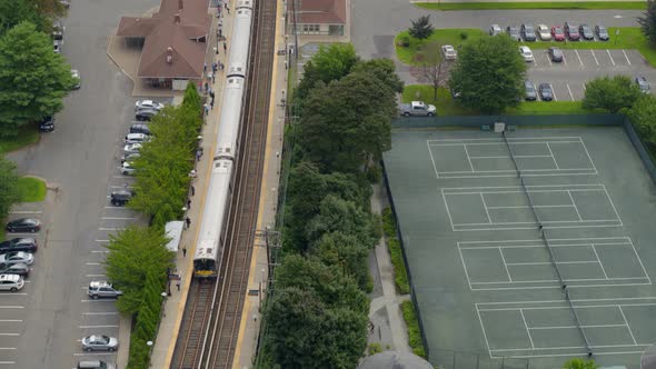 Aerial View of MTA Train Arriving at Station Near Tennis Courts in Long Island alt