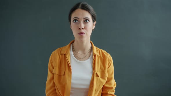 Slow Motion Portrait of Confused Young Lady Rolling Eyes Then Looking at Camera with Shy Face alt