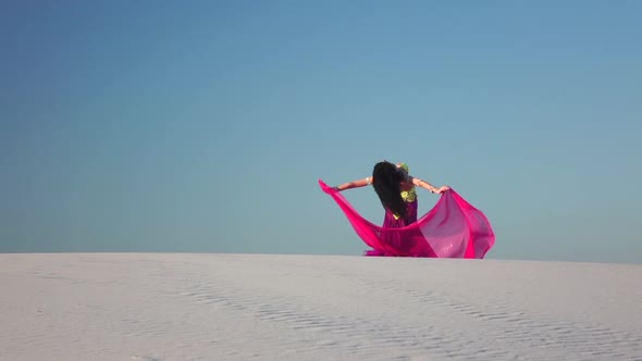 Dancer in the Sandy Desert in the Hands of a Pink Pink Veil. Slow Motion alt