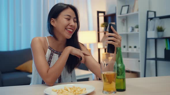 Young Asia lady drinking beer having fun happy moment night party New Year event online celebration.