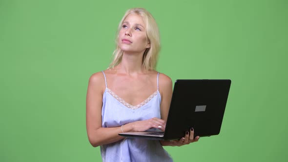 Young Happy Beautiful Businesswoman Thinking While Using Laptop