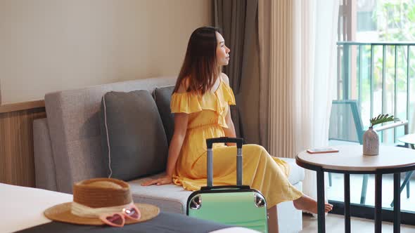 Young woman traveler sitting and relaxing in a hotel room
