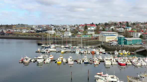 Flying Over Boats Docked At Marina With Traffic Driving On Seaside Road In The Background. - aerial alt