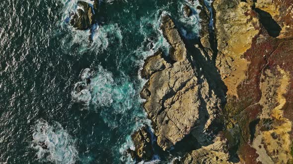 Aerial top view of ocean blue waves break on a coastline alt