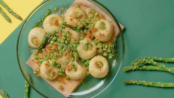 Vertical Flat Lay Food Video the Cook Puts Plate of Cooked Potato Dumplings with Backed Asparagus
