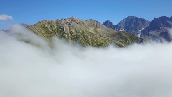 Peak of Foggy Green Mountains and Cloudscape under Blue Sky
