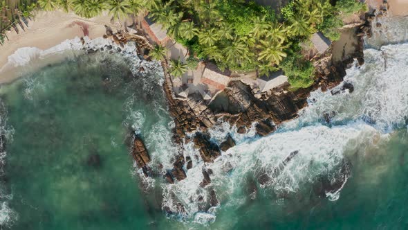 Ocean Waves Crash Against Stony Rocks During Sunset on the Island of Sri Lanka. Aerial View