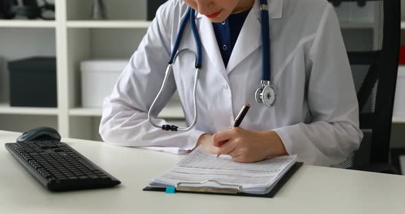 Cropped Image of Female Doctor Typing on Keyboard and Filling Documents
