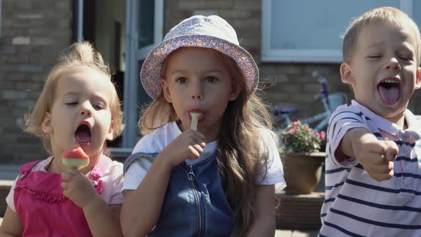 Three Cute Little Children Enjoys Delicious Ice Cream Cone alt
