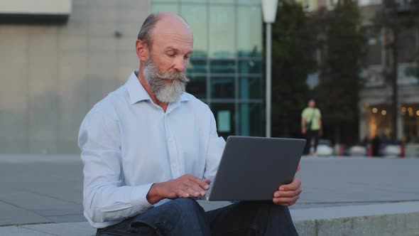 Serious Ponder Pensioner Writer Creative Worker Sitting Outdoors Using Laptop Works Remotely Online alt