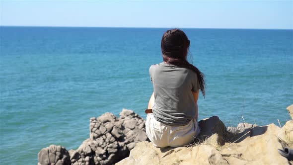 Tourist Woman Outdoor on Edge of Cliff Seashore