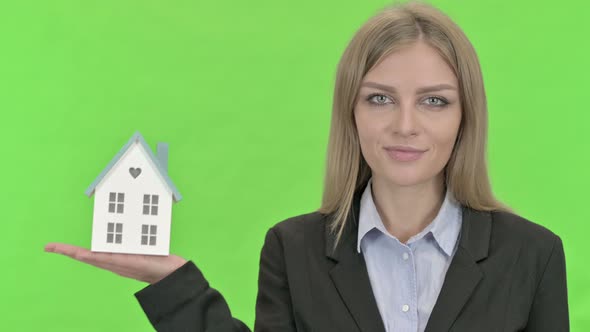 Cheerful Businesswoman Holding Model House Against Chroma Key alt