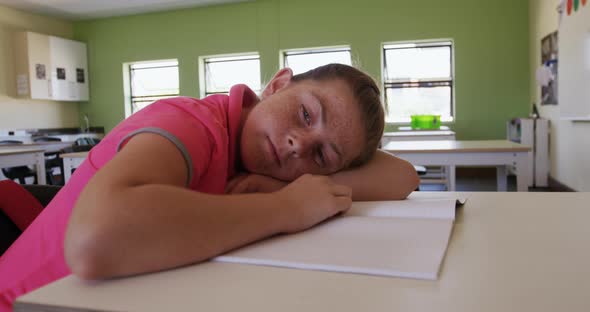 Girl with his head on desk in the class alt