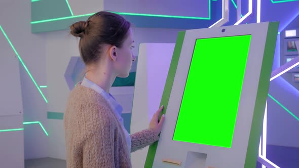 Green Screen Concept - Woman Looking at Blank Green Display Kiosk at Exhibition