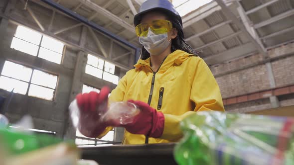 Womanvolunteer in Yellow Jacket and Transparent Protecting Glasses Hard Hat and Mask Sorting Used alt