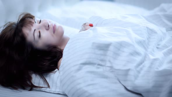 Cinematic Happy Brunette Woman Puts Her Head on the Pillow and Falls Asleep in the Evening alt