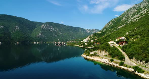 Road in Mountains Along the Crystal Clear Lake Aerial View alt