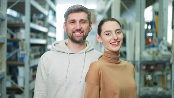 Portrait of Happy Young Satisfied Couple Posing in Hardware Store Indoors alt