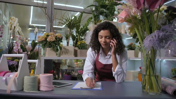 Florist Taking Order on Phone in Flower Shop alt