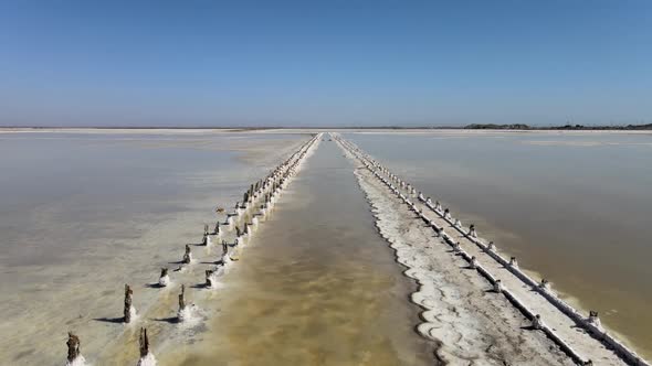 Abandoned Pier on Multicolored Lake Medicinal Clay Ungraded on Sunset, Air Drone View alt