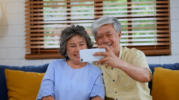 Asian senior couple having video chat using a smartphone.