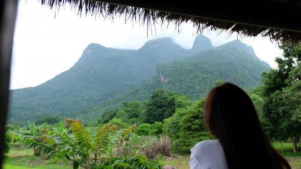 Rear view of a female traveler looking at a beautiful mountains view