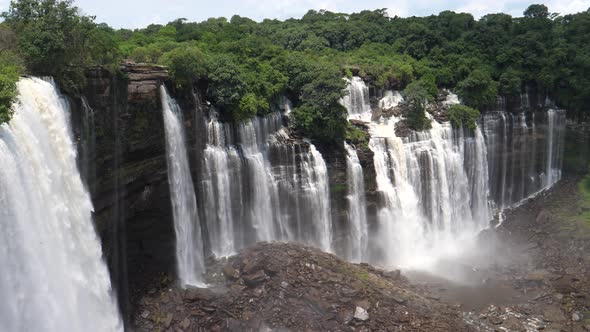 Pan from streams of water falling down at the Kalandula Falls in Angola alt