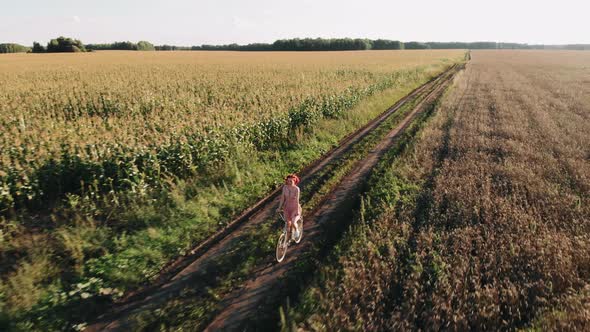 Portrait of Dreamy Romantic Girl in Sundress on Vintage Retro Bicycle at Meadow in Sunset Light alt