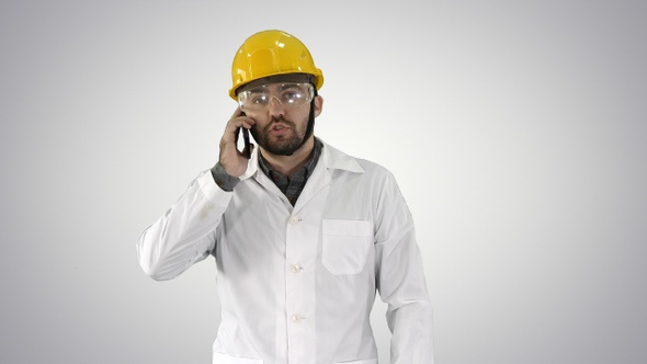 Engineer in protective glasses and hat walking taking alt