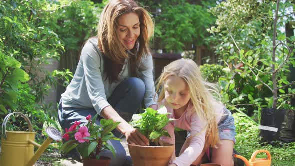 Mother and daughter are replanting in the garden alt