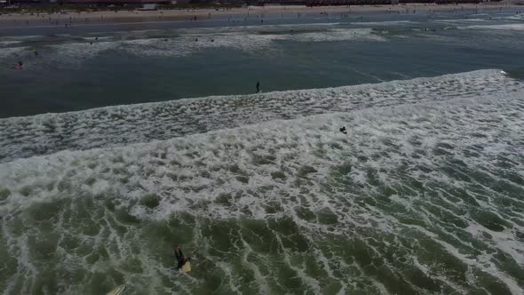 Drone shot of surfers at Muizenberg beach, Cape Town - drone is following a fliteboard surfer from b alt