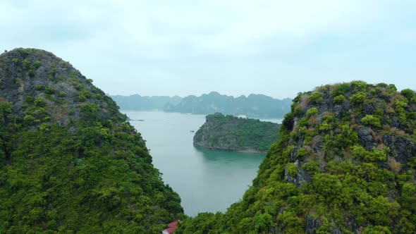 Aerial: flying over Ha Long Bay rock pinnacles, famous tourism destination in Vietnam alt