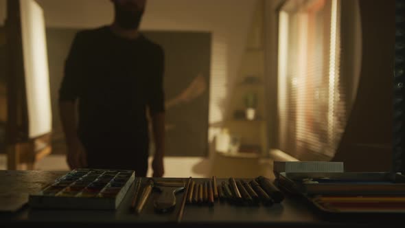 A Sketch Artist Choosing a Pencil alt