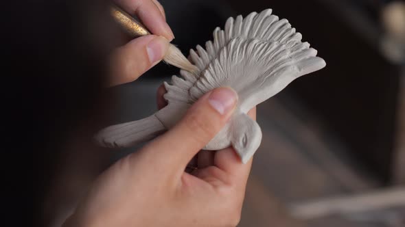 Close Up Portrait of Potter Woman Hands Working on Details of a Clay Handcraft Bird alt