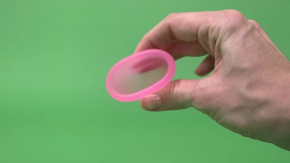 Pink Menstrual Cup Closeup on a Green Background