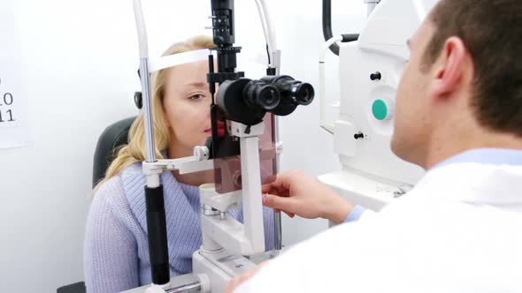 Optometrist examining female patient on slit lamp alt