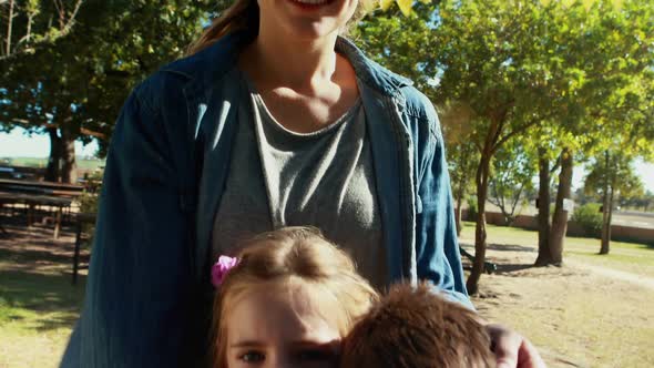Portrait of happy mother and kids standing in park 4k alt