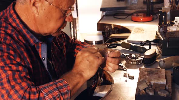 Goldsmith fixing diamond on ring alt