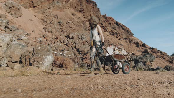 Woman Going with Cart in Post Apocalyptic Desert alt