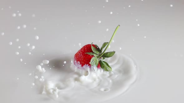 Strawberry Falling With Splashes Into Milk