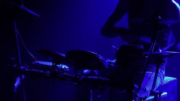 Professional Musician Playing Drums and Percussion Cymbals in a Dark Smoky Studio with Blue Lights alt