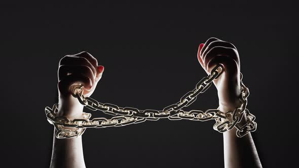 Hands breaking chains. Metal or steel chain is blown to pieces. Break free. alt