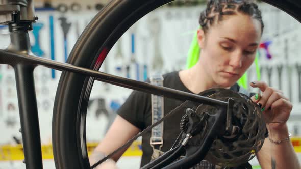 Female Technician Fixing Wheel of Bike