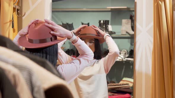 Beautiful Woman Trying on a New Hat, While Shopping at Clothing Store alt