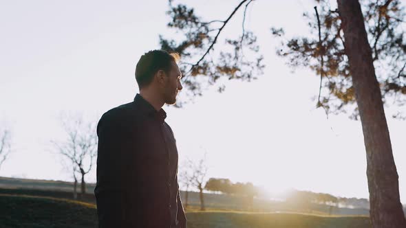 The Serious and Handsome Man Isolated in Nature at Sunset Looked Thoughtfully in Parts alt